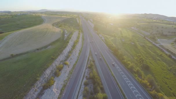 Vehicles moving on interstate highway. Beautiful sunset on horizon. Aerial shot — Stock Video