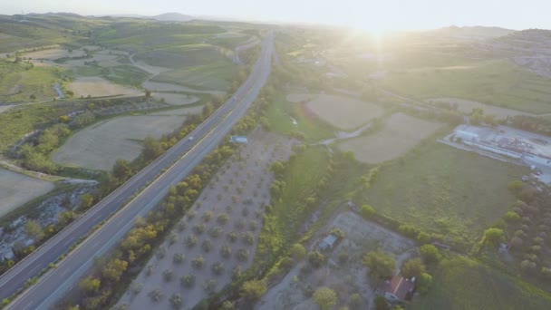 Drukke verkeer op de weg. Luchtfoto van zorgvuldig gecultiveerde landbouwgrond, tuinen — Stockvideo