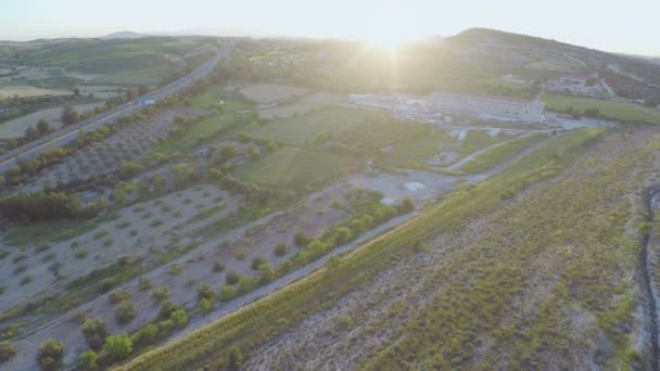 Aerial shot of cultivated arable land plots. Active traffic on modern highway — Stock Video