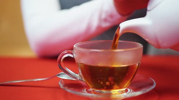 放松，晚上在家里。女人倒一杯茶。热和可口的饮料 — 图库视频影像