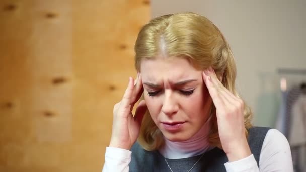 Mujer rubia con dolor de cabeza, crisis nerviosa en el trabajo. Estrés y problemas — Vídeo de stock