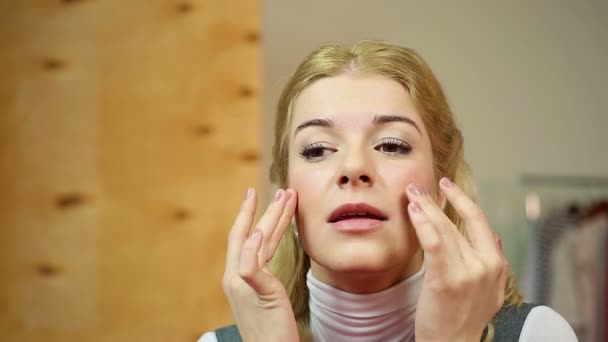 Женщина наслаждается результатами процедуры омоложения лица, чувствуя мягкость кожи — стоковое видео