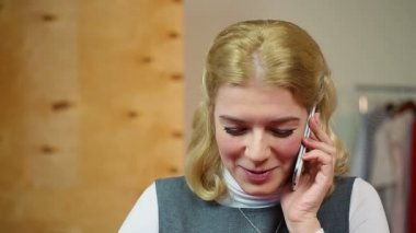 Cep telefonu üzerinde bir arkadaşıyla konuşurken, eğleniyor ve gülümseyerek mutlu bir kadın