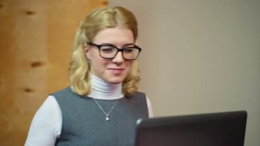 İyi haber, dinledikten sonra gülüyor kadın Ofis Yöneticisi bilgisayarda çalışarak