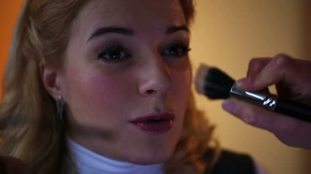 Gelukkig client zitten in de schoonheidssalon. Geschoolde kunstenaar toepassing van make-up op huid — Stockvideo