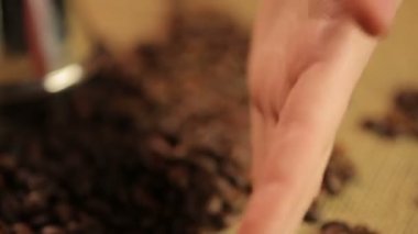 Kavrulmuş kahve çekirdekleri güçlü tat zevk için hazırlanıyor, dokunmadan kadın eli