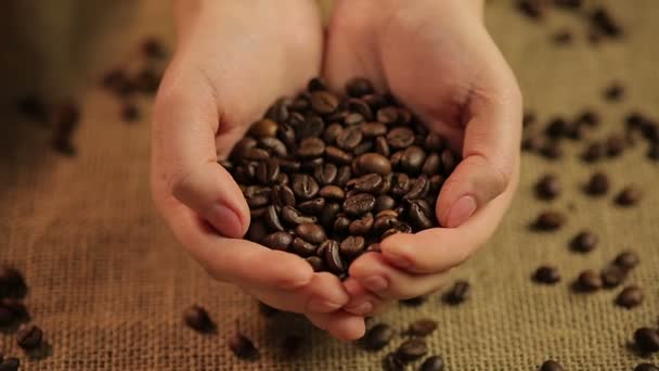 Frau mit einer Handvoll geschmackvoll gerösteter Kaffeebohnen, dem Lieblingsgetränk der Welt — Stockvideo