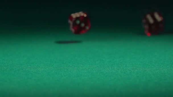 Красные кости падают на зеленый стол в замедленной съемке. Казино азартные игры, хобби для богатых — стоковое видео