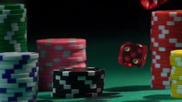 Пачки фишек на зеленом покерном столе, бросают кости в замедленной съемке. Азартные игры — стоковое видео