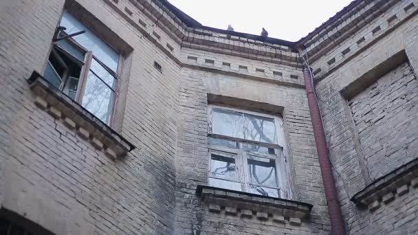 Gamla tegelbyggnaden med gamla fönster och olycksbådande fåglarna sitter på taket — Stockvideo