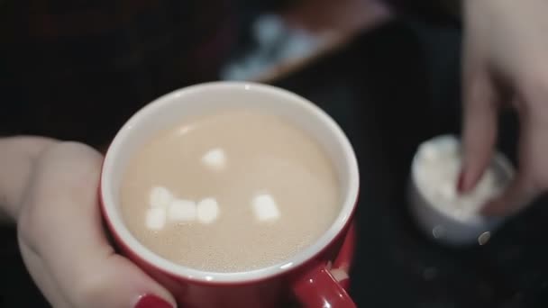 Close-up shot van vrouwelijke handen zoete marshmallow toevoegen aan kop warme koffie — Stockvideo