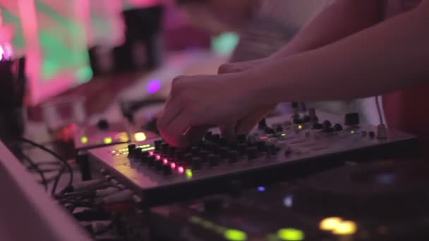 Manos de macho dj girando controles en equipos de sonido, tocando música en discoteca — Vídeo de stock