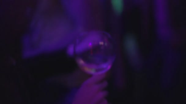 Mulher bonita movendo-se para a música na pista de dança com copo de vinho, festa — Vídeo de Stock