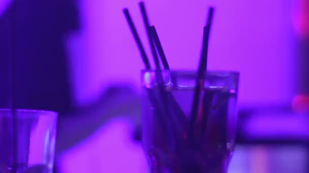 Closeup of alcohol cocktail in glass on bar counter, dj performing in nightclub — Stock Video