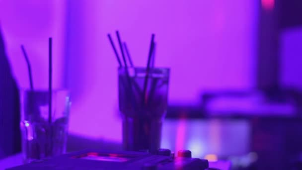 Dj играет музыку на вечеринке, стаканы с алкогольными напитками стоят на барной стойке — стоковое видео
