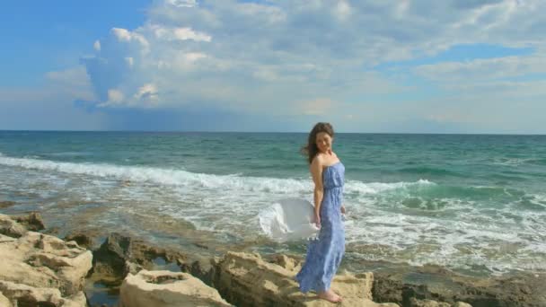 Hermosa mujer morena en maxi vestido disfrutando de un día ventoso en la orilla del mar, vacaciones — Vídeos de Stock