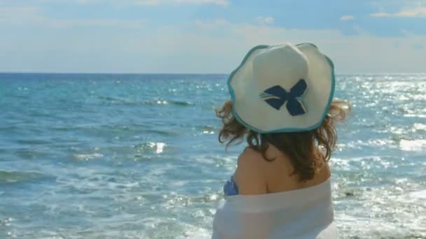 Mujer solitaria mirando olas tormentosas, sol de verano brillando en la superficie del agua de mar — Vídeo de stock