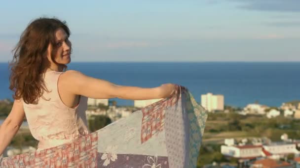 Belle femme heureuse dansant avec écharpe, paysage de mer incroyable en arrière-plan — Video