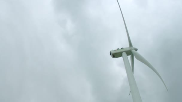 下で回転する巨大な風力タービン翼灰色の雨、嵐、垂直方向のパノラマ — ストック動画