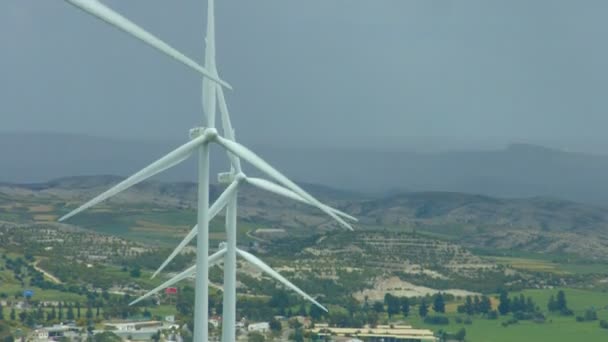 Vertikale Ansicht von sich drehenden Windkraftanlagen, erstaunliche ländliche Landschaft, regnerischer Horizont — Stockvideo