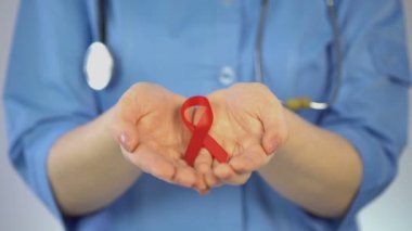 Mavi paltolu kırmızı kurdele avuç içi, AIDS konusunda tutan kadın jinekolog