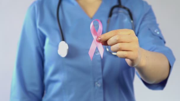 Médico femenino con cinta rosa, símbolo internacional de conciencia sobre el cáncer de mama — Vídeos de Stock