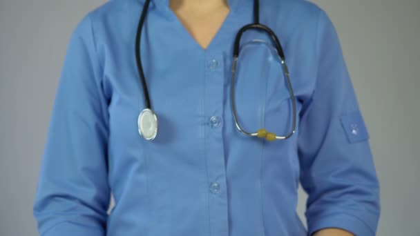Γυναίκα γιατρός στον μπλε παλτό προειδοποίησης σχετικά με τις σοβαρές ασθένειες, κρατώντας πινακίδα stop — Αρχείο Βίντεο