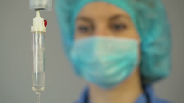 Infirmière vérifiant compte-gouttes avec des médicaments, prodiguant les premiers soins au patient — Video