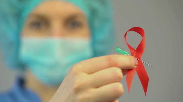 Ženský lékař drží červenou stužku, mezinárodní Aids, Hiv povědomí symbolu — Stock video