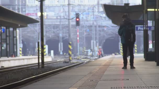 Mladý samec turista s batohem, čekání na vlak na nástupišti, cestování — Stock video
