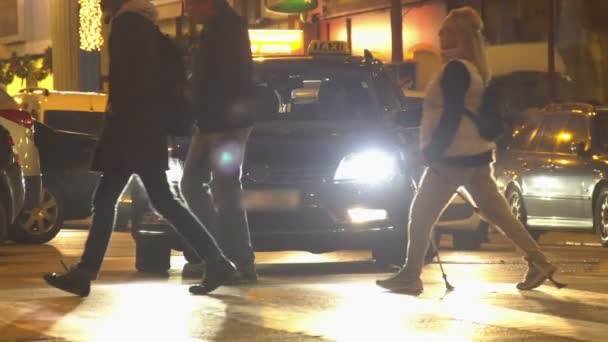 Gente cruzando la calle en el paso de peatones, por la noche, relajación. Lento. — Vídeo de stock