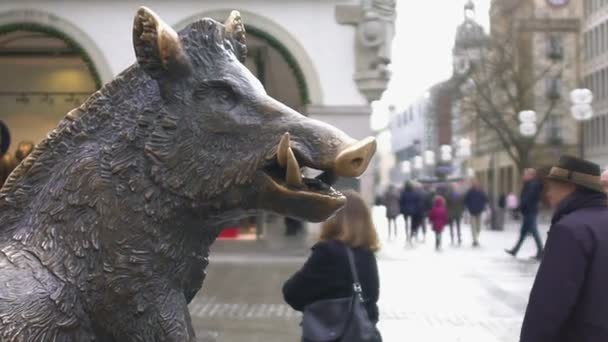 Бронзовая статуя кабана в историческом центре города, туристы ходят вокруг — стоковое видео