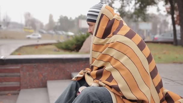 Lonely homeless man covered with shabby blanket feeling cold, asking for money — Stock Video