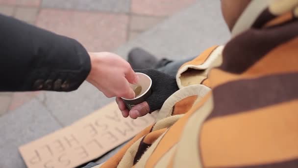 Arme bedelen voor goede doelen in de straat, sympathieke stadsmensen geld geven — Stockvideo