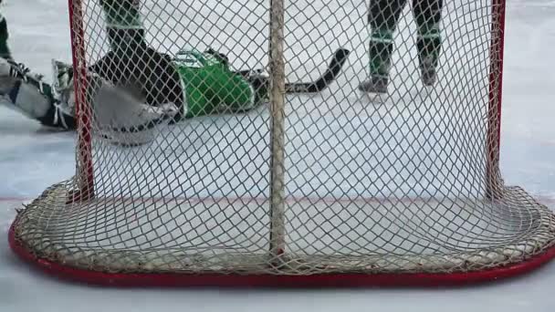 Vue de derrière le filet, gardien de hockey repoussant une attaque violente, attrapant la rondelle — Video