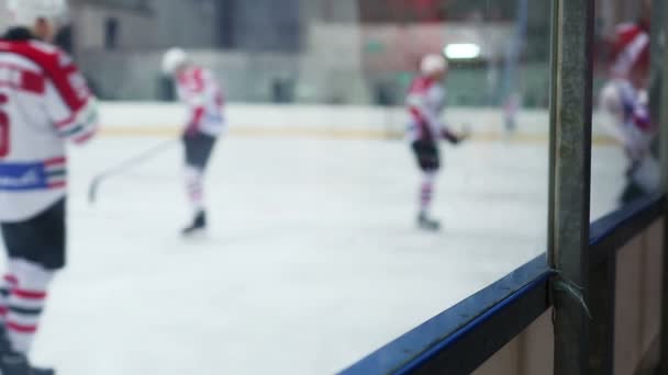 Хоккейные команды заменяют игровых смен во время матча, рефери наблюдает за игрой — стоковое видео