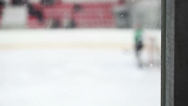 View through the glass at goaltender defending team's net from rival's puck — Stock Video