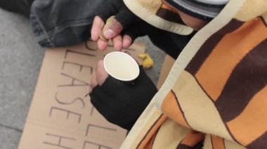 Para sayma ve kağıt bardak, üzüntü ve yoksulluk koyarak erkek dilenci