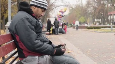 Bira şişesi, kötü yaşam tarzı seçimleri ile parkta bankta oturmuş alkol bağımlısı