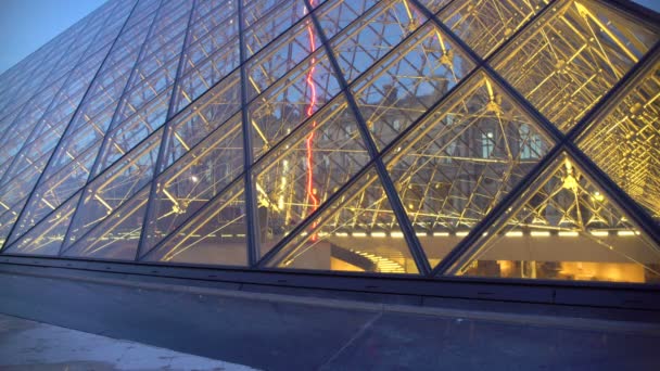 PARIS, FRANCE - CIRCA JANUARY 2016: Tourists going sightseeing. Happy couple enjoying a stroll outside Louvre Palace, viewing glass pyramids — Stock Video