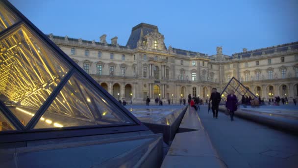 PARÍS, FRANCIA - CIRCA ENERO 2016: Turistas haciendo turismo. Multitud de viajeros disfrutando de la visita al Museo del Louvre, viendo pirámides de vidrio — Vídeo de stock