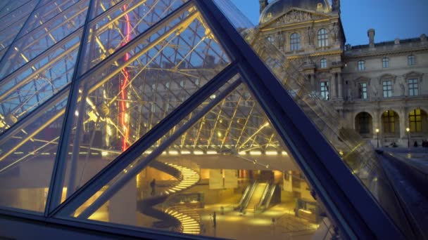 Turisti che visitano il museo d'arte del Louvre, veduta attraverso la piramide di vetro, visita a Parigi — Video Stock