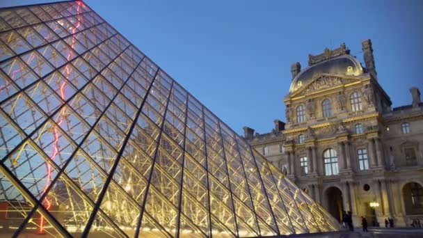 Louvre Construcción de vidrio piramidal brillantemente iluminado por las luces de la noche, París — Vídeos de Stock