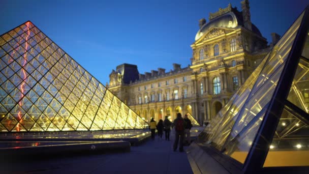 Boldog fiatalember jelentő közelében Louvre piramisok, élvezve a városnézés utazás Párizsba — Stock videók