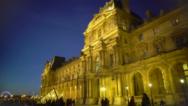 Menigte van mensen genieten van nacht uitzicht van het Louvre paleis, sightseeing tour naar Parijs — Stockvideo