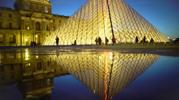 Louvre Pirâmide reflexão sobre a superfície da água, silhuetas de turistas no museu — Vídeo de Stock