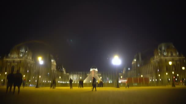 Mroczne niebo nad jaskrawo oświetlony Pałac Luwru i piramidy, noc Paryż — Wideo stockowe