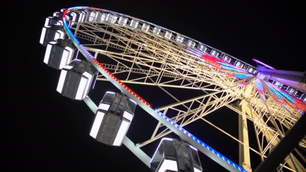 Giant wheel starts rotating and gaining speed, bright illumination sparkling — Stock Video