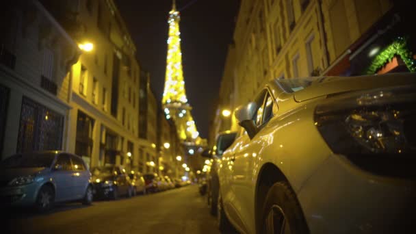 Torre Eiffel desenfocada brillando al final de la calle estrecha, noche en París — Vídeo de stock
