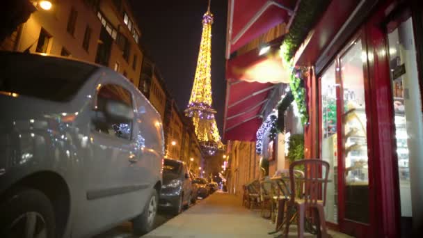 Hermosa Torre Eiffel brillando en París por la noche, vista desde la bonita cafetería de la calle — Vídeos de Stock